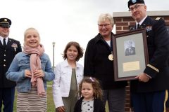 Colonel (Ret.) April M. Corniea poses with her family and plaque during the unveiling after the Court Of Honor Induction Ceremony on Camp Ripley on October 6th 2019.