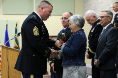 Command Sergeant Major Erikson presents a rose to the family of Colonel (ret.) Wayne M. Hayes during the Court of Honor Induction Ceremony on Camp Ripley on October 6th 2019.