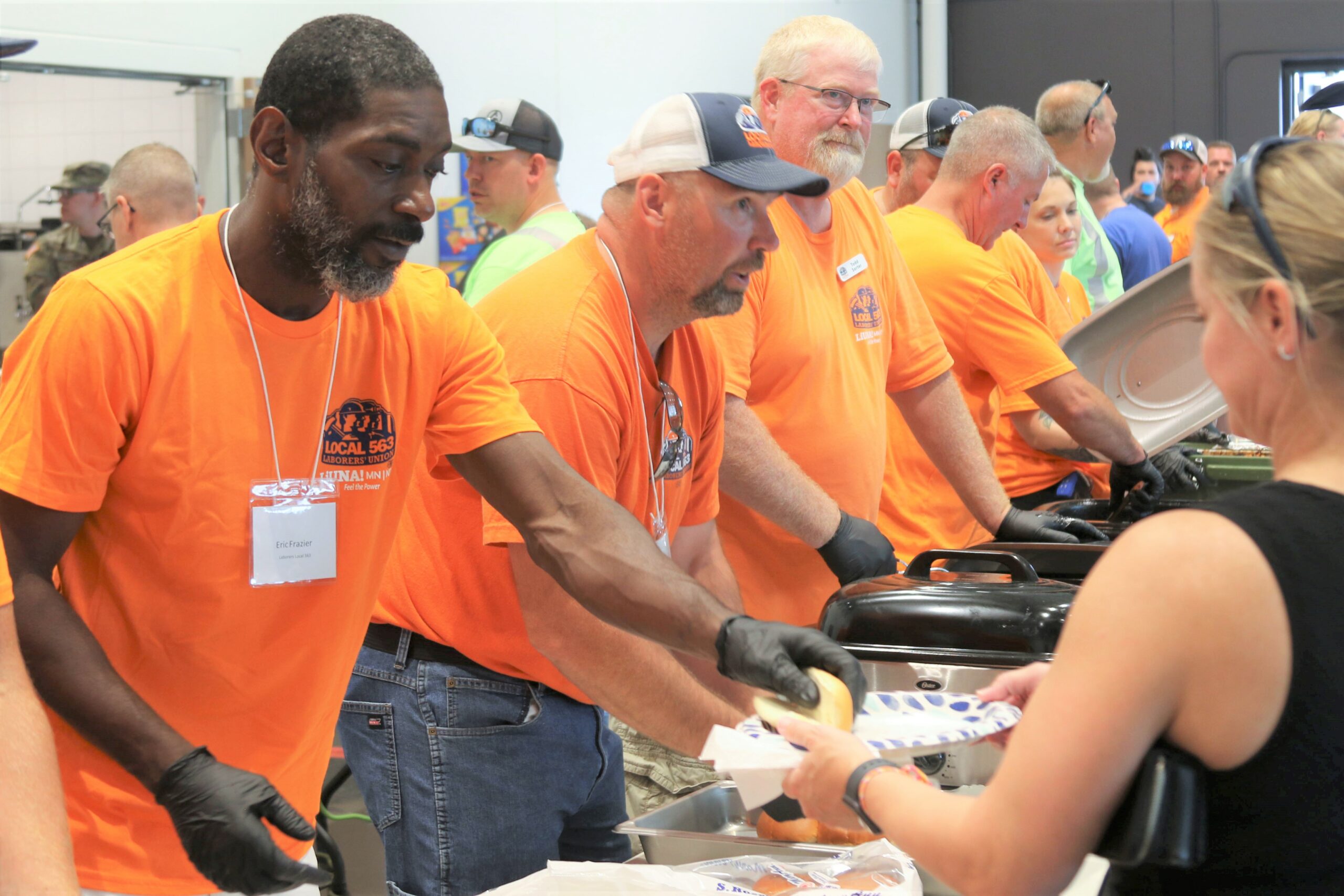 Volunteers from Minnesota Builders Association serve food to families at the 34th Red Bull Infantry Divison Family Day at Arden Hills Army Training Site, July 23, 2023. (Minnesota National Guard photo by Spc. Andrew Nayenga)